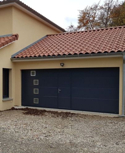 Pose d'une porte de garage sectionnelle gris anthracite avec portillon et hublots à Lyon